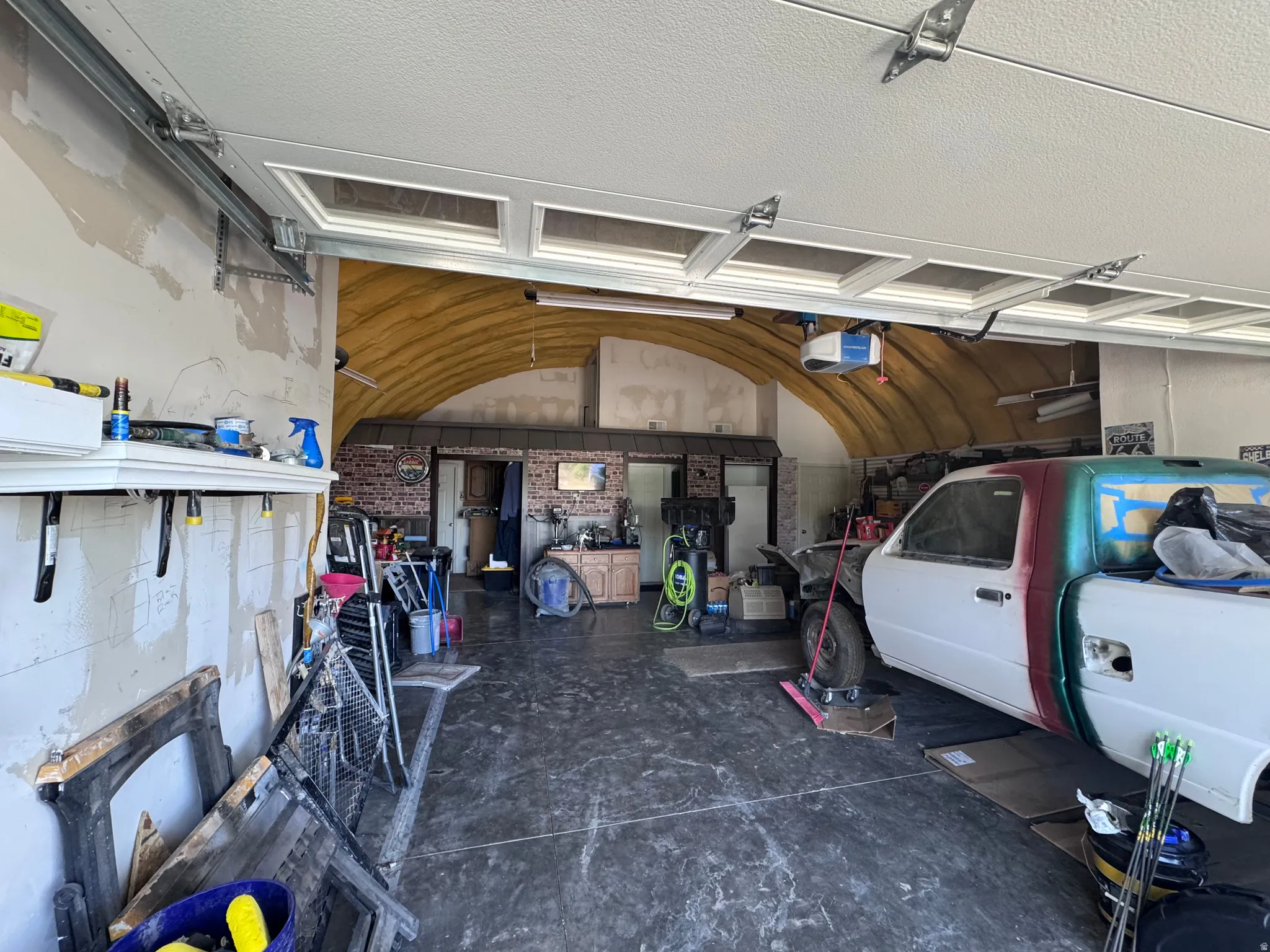 Spacious garage featuring a concrete floor and arched ceiling
