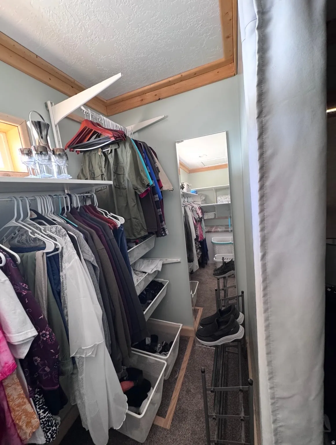 Walk-in closet featuring extensive built-in shelving, hanging rods, and a full-length mirror