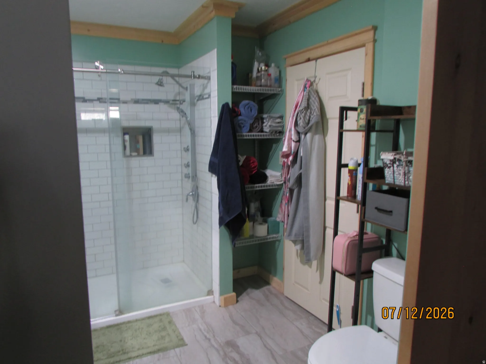 Contemporary bathroom featuring a glass-enclosed shower with subway tile surround and a recessed shower niche