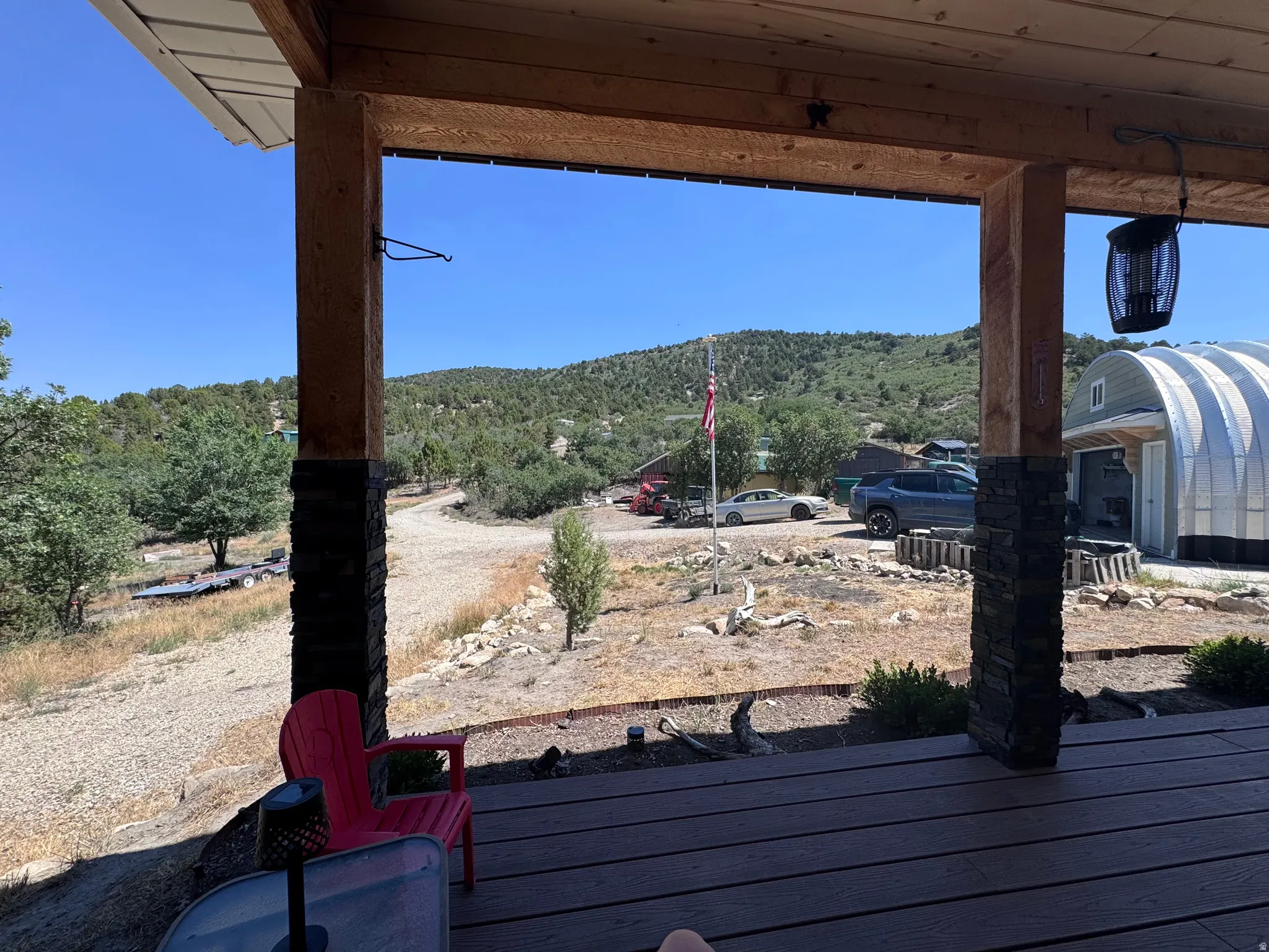 Expansive outdoor deck featuring wood-finish decking and structural wood posts with stacked stone accents
