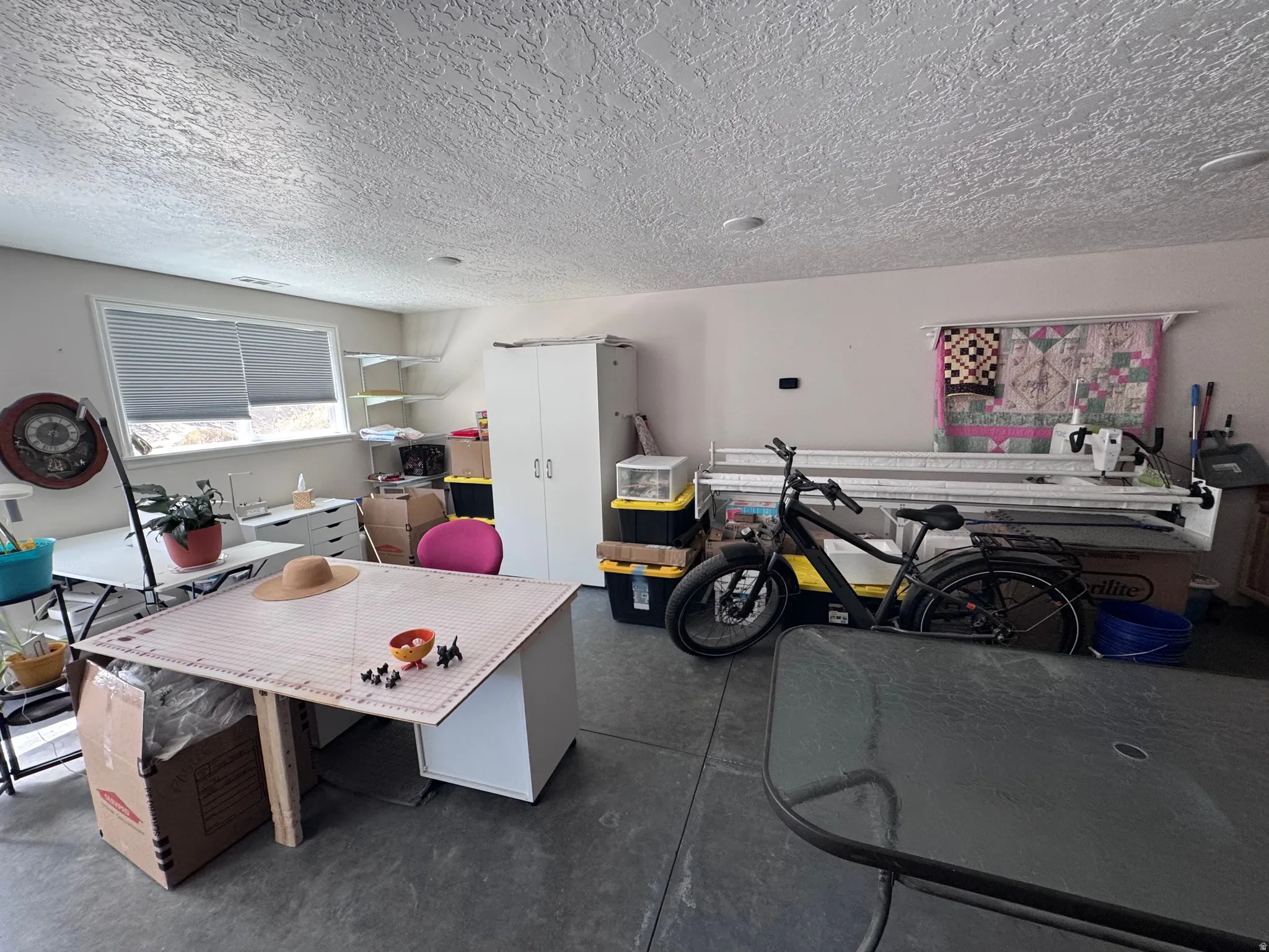 Versatile garage space featuring concrete flooring, overhead storage racks, built-in cabinetry, and ample room for vehicles and equipment
