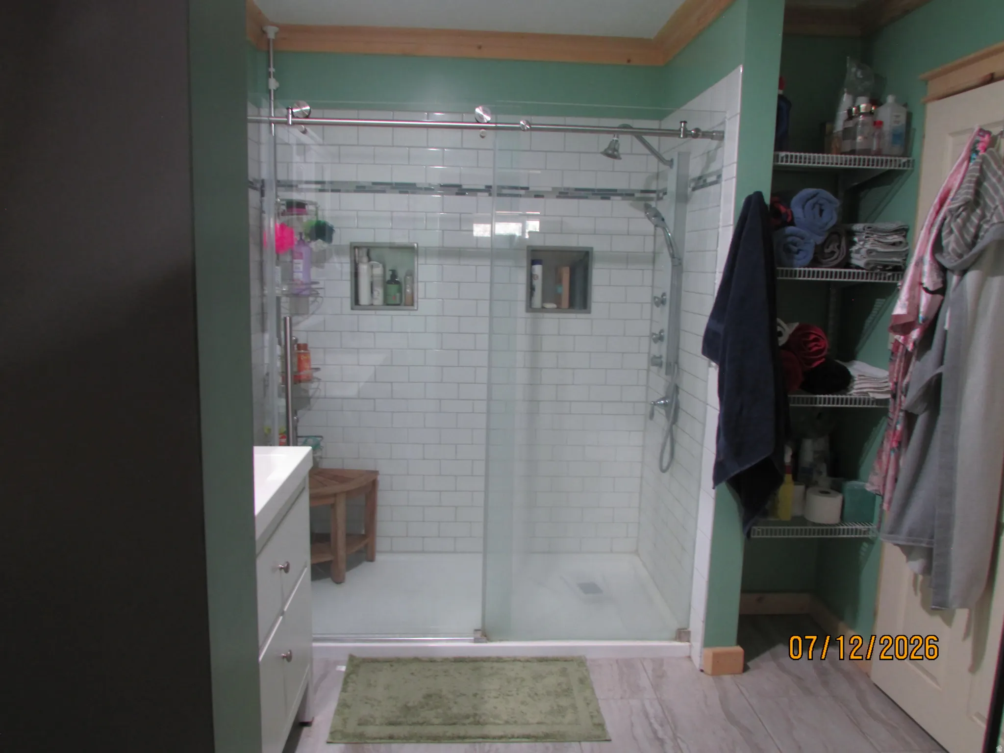 Glass-enclosed shower featuring subway tile surround, dual recessed niches, and multiple showerheads
