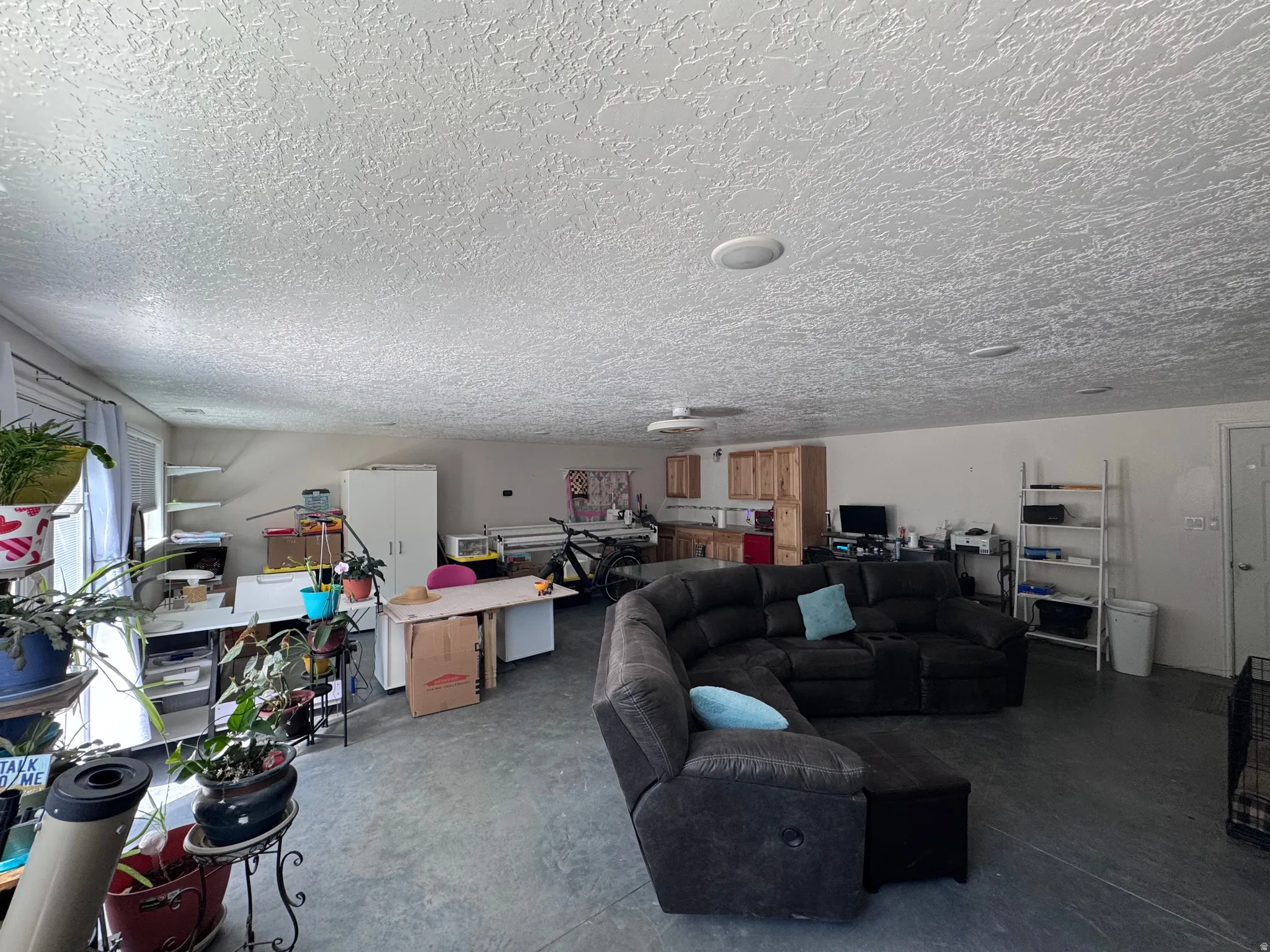 Spacious room featuring concrete flooring and light-toned walls