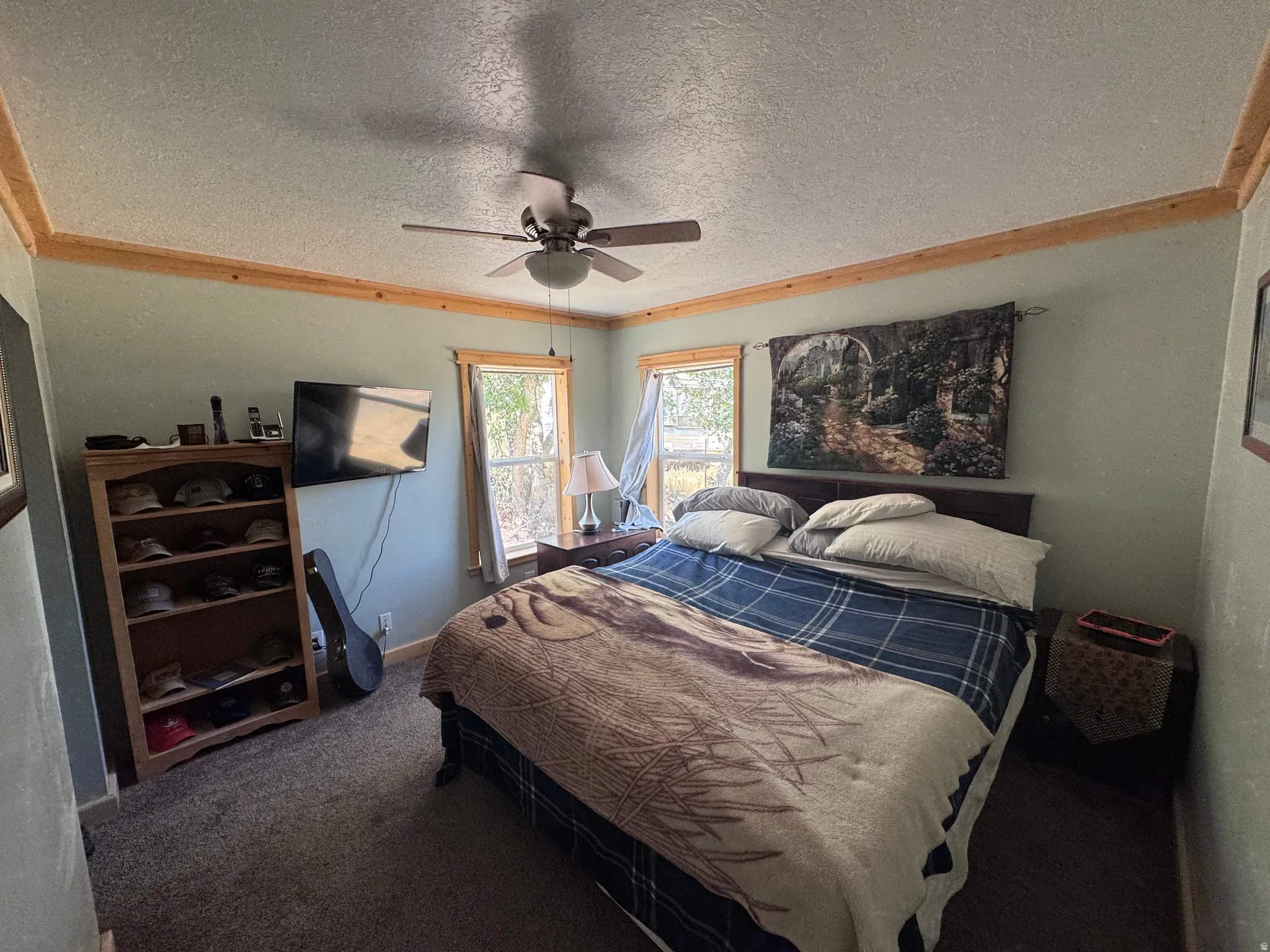 Room featuring two windows, crown molding, and wood-finish trim