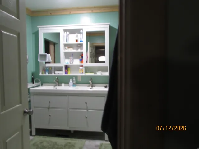 Dual vanity with integrated sinks, white cabinetry, and brushed nickel hardware