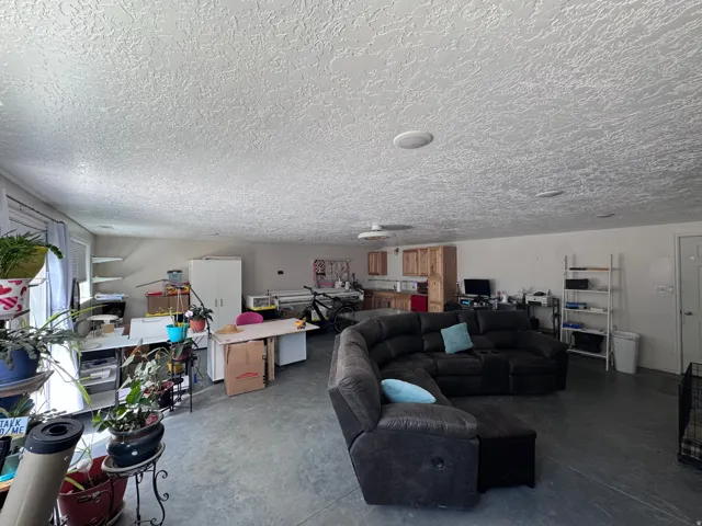 Spacious room featuring concrete flooring and light-toned walls