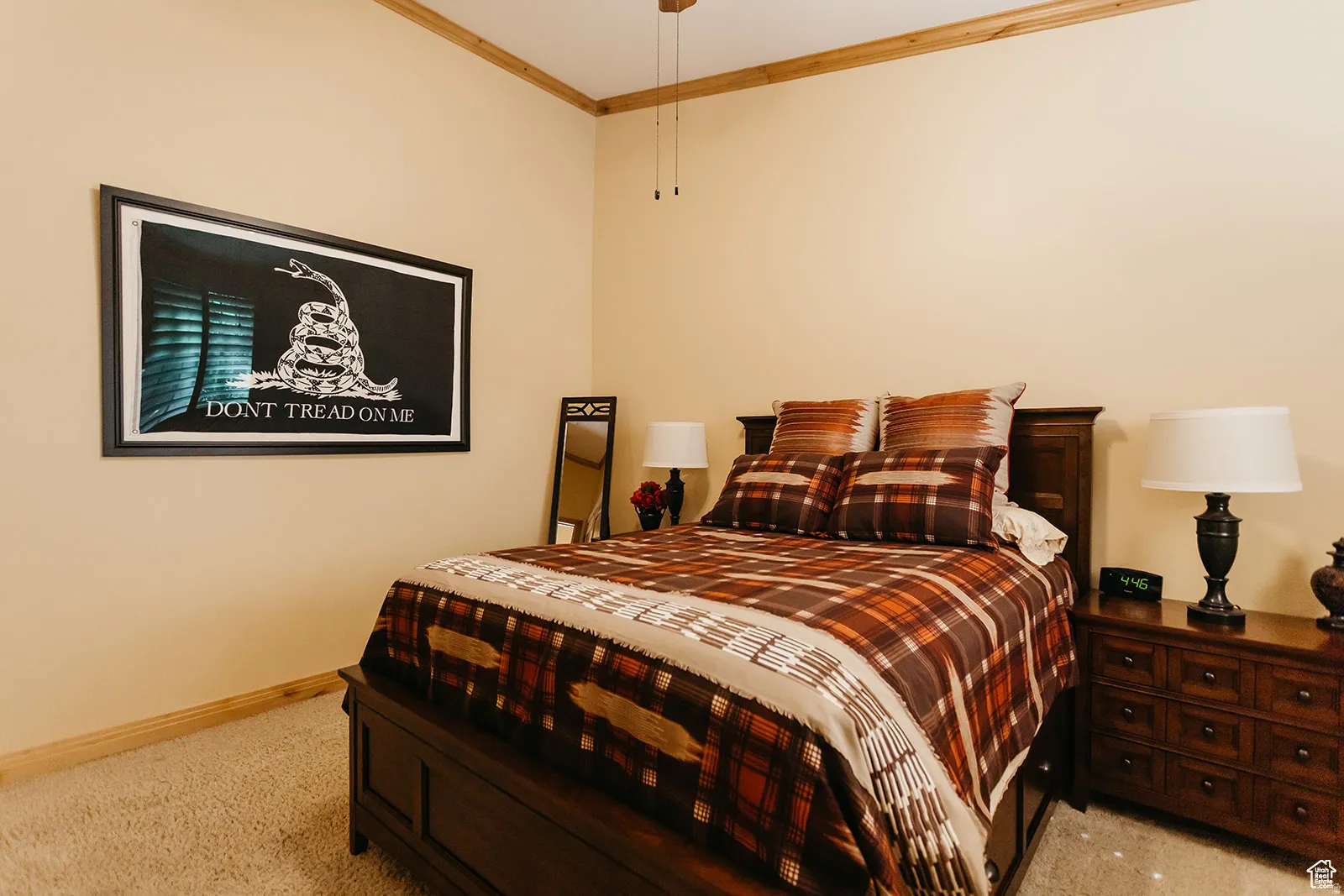 Carpeted room featuring a ceiling fan, wood trim, and light-colored walls