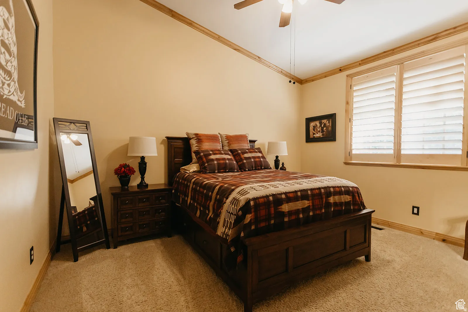 Bedroom featuring warm neutral wall tones and a textured carpet