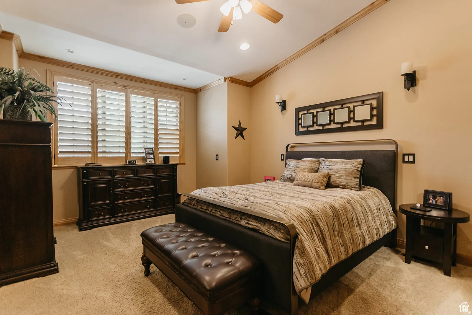 Spacious sleeping area featuring vaulted ceilings with wood-finish trim, plantation shutters, recessed lighting, and a ceiling fan