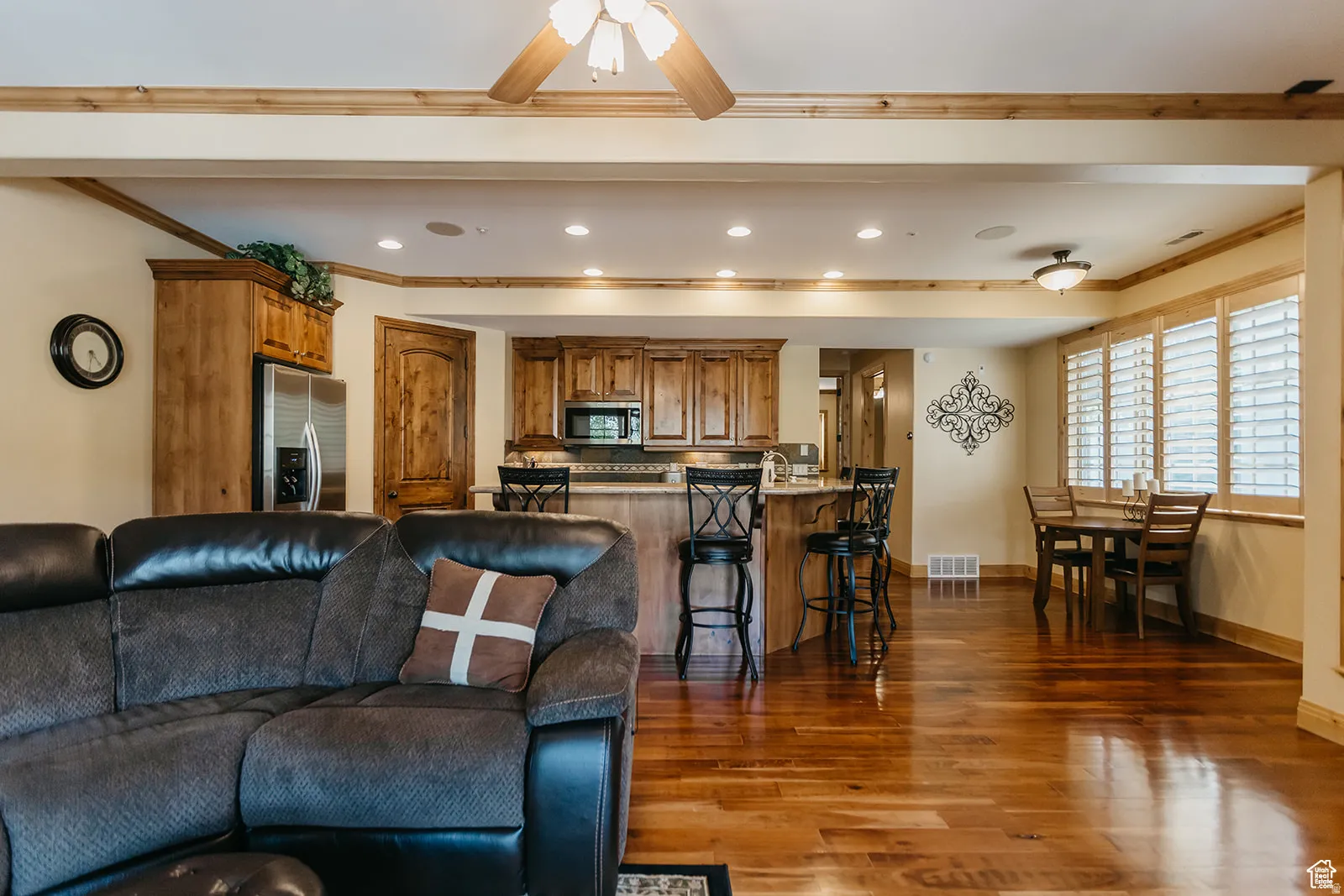 Expansive open-concept living area featuring wood-finish flooring, recessed lighting, and a ceiling fan