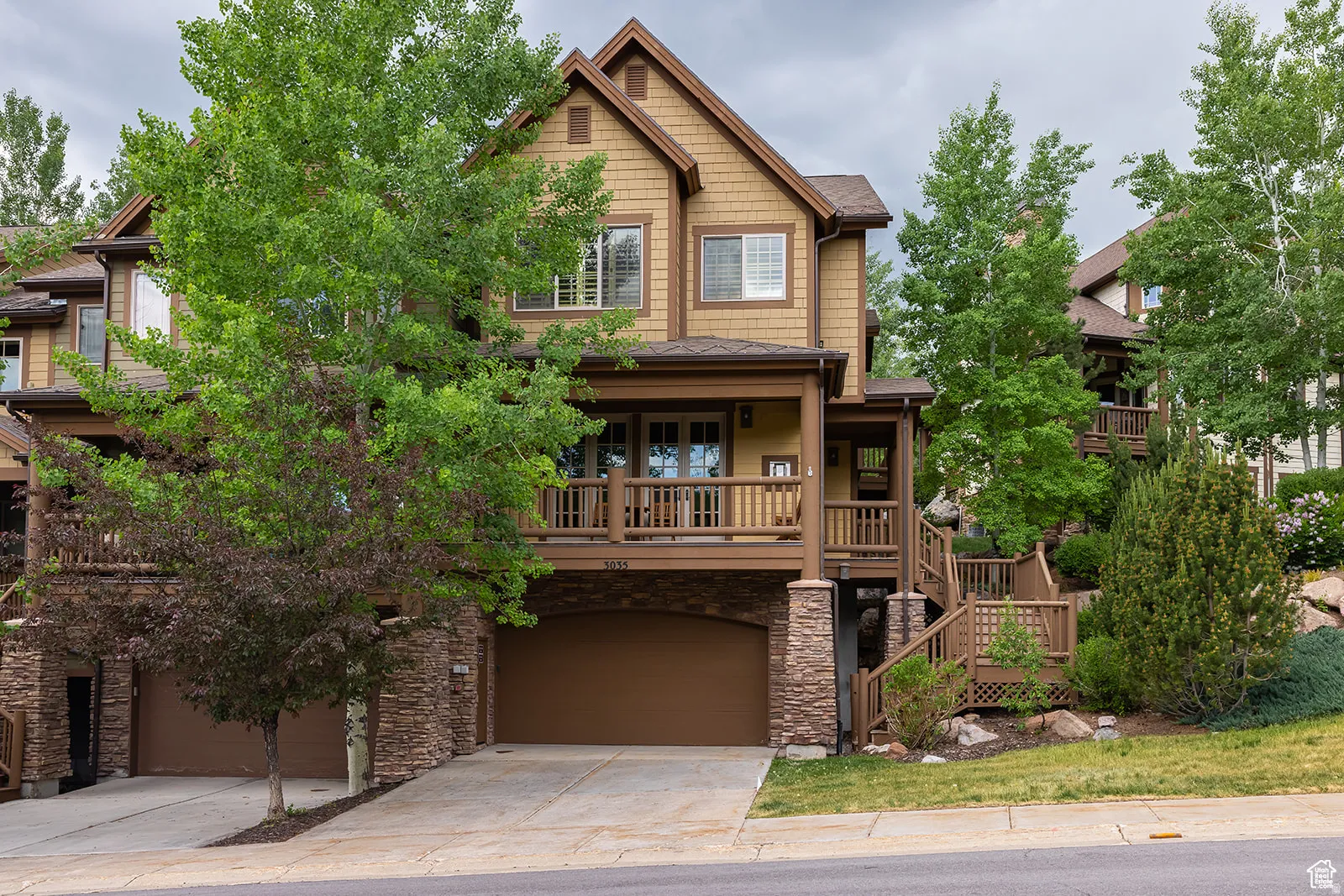 Two-story residence featuring a ground-level two-car garage and a second-level balcony