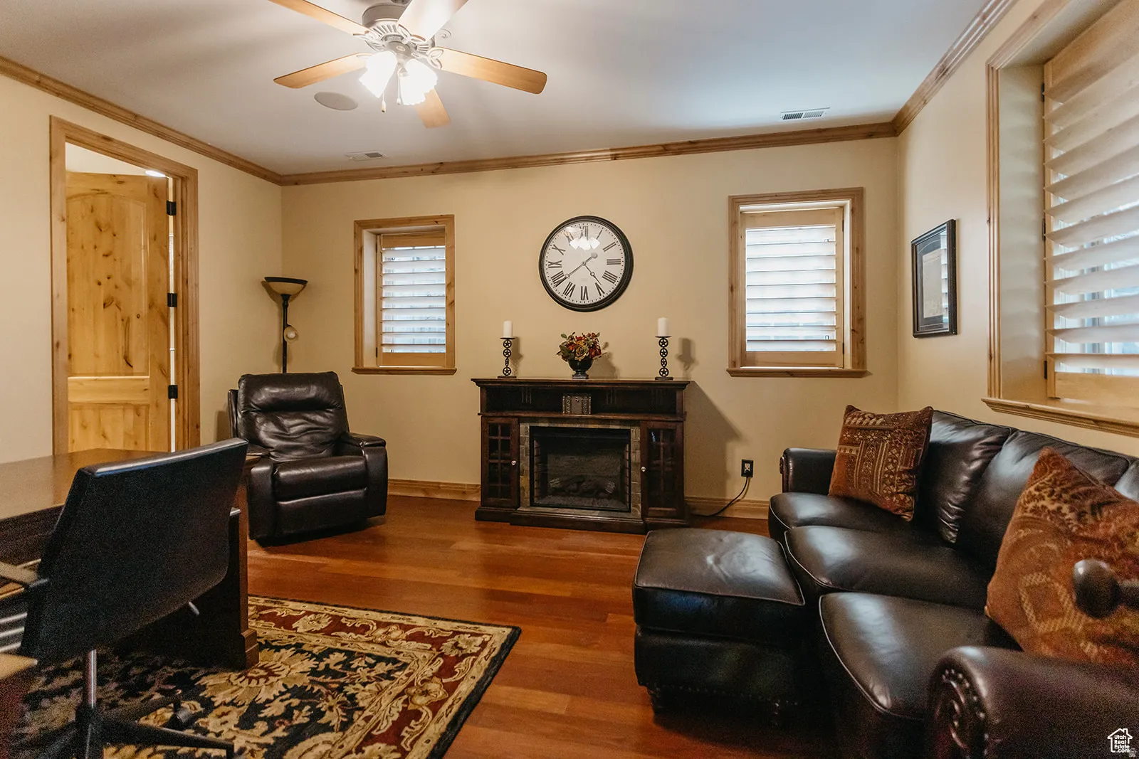 Inviting room featuring rich wood-finish flooring, a built-in electric fireplace, and natural wood trim throughout