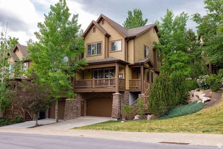 Multi-level residence featuring a shake siding exterior, stone accents, and an integrated two-car garage