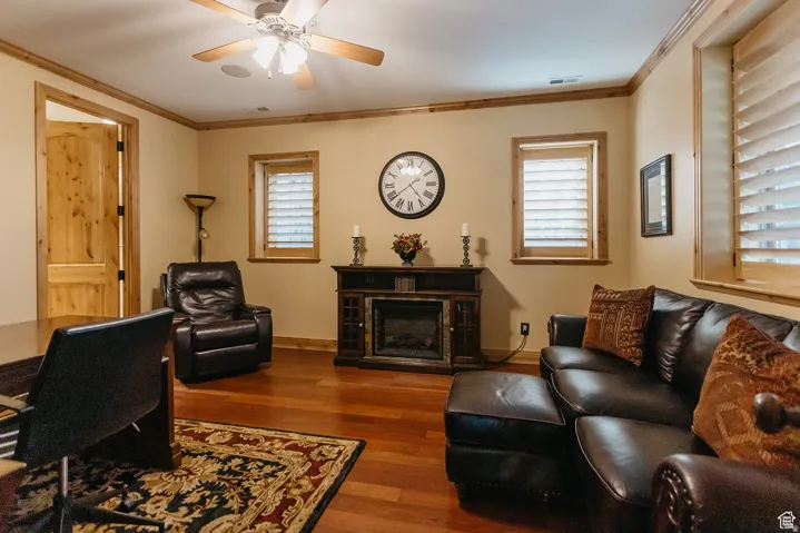 Inviting room featuring rich wood-finish flooring, a built-in electric fireplace, and natural wood trim throughout