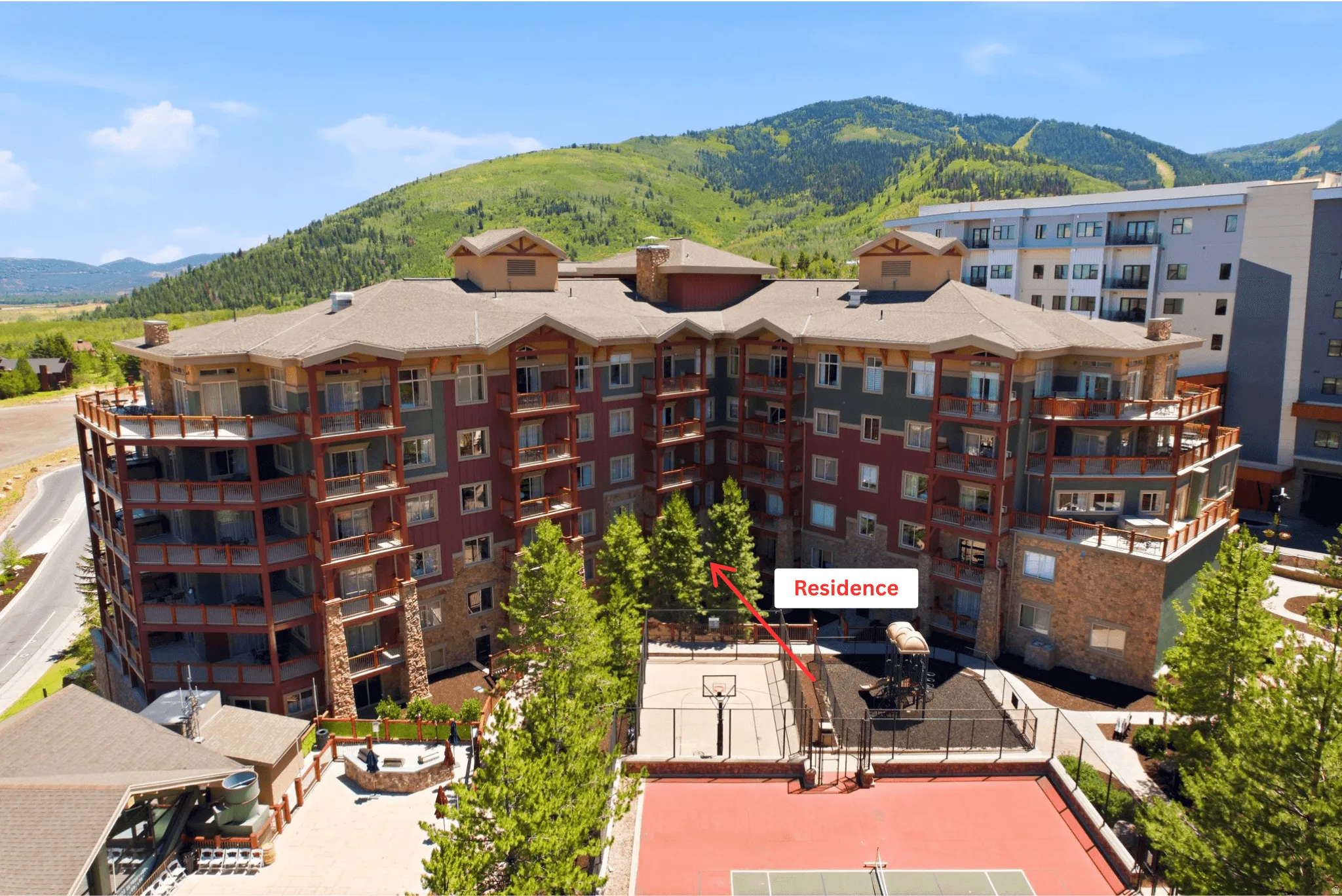 Multi-story residential building with stone and wood siding accents