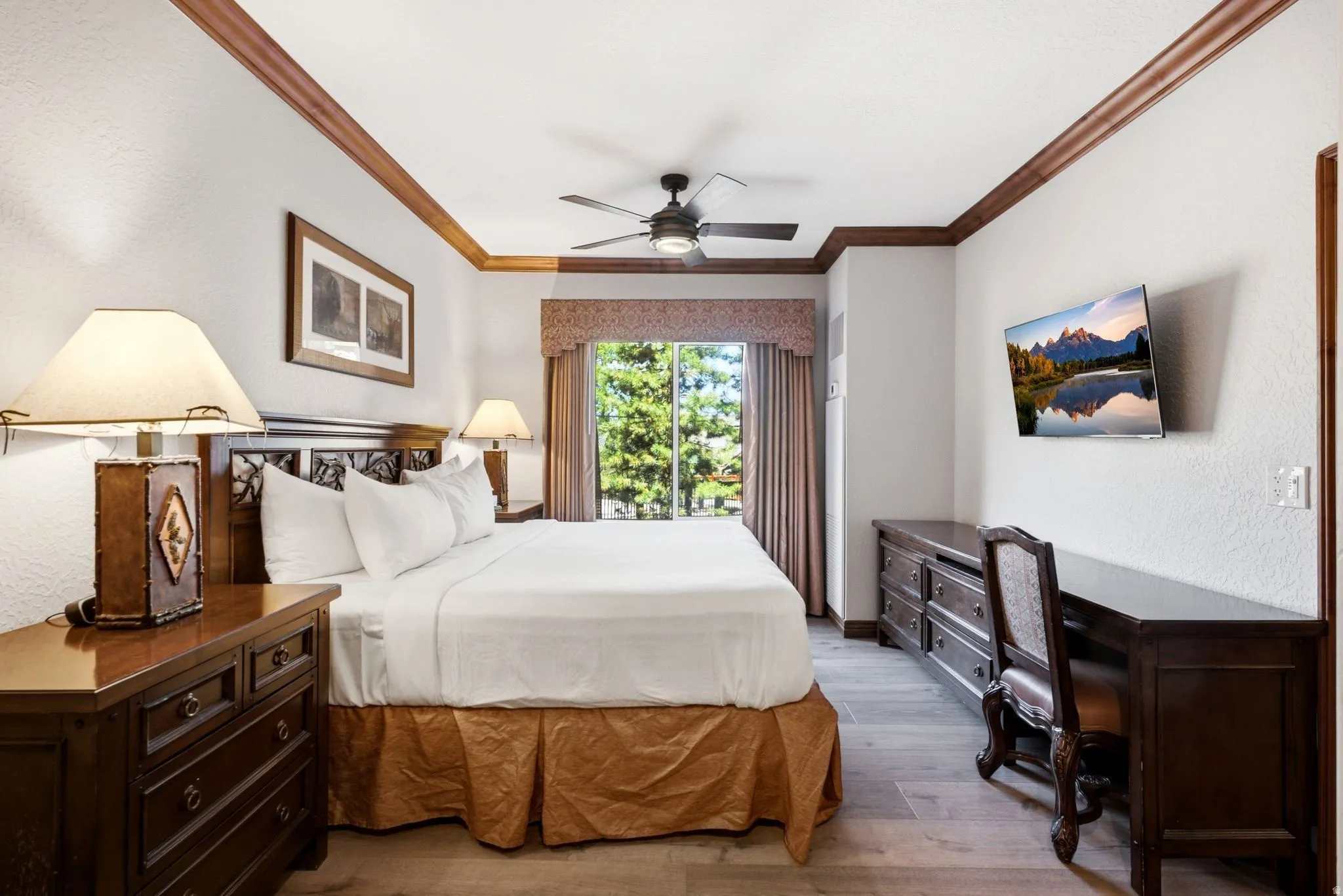 Bedroom featuring wood-finish flooring, a ceiling fan, and a window with drapes
