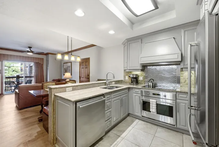 Modern kitchen featuring gray cabinetry, granite countertops, and stainless steel appliances