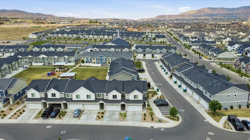 Extensive residential community featuring townhomes with attached garages and paved driveways