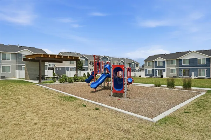 Community playground area featuring a multi-level play structure with slides and tunnels