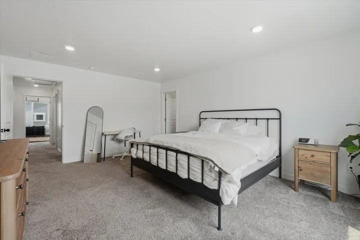 Carpeted bedroom featuring white walls and recessed ceiling lighting