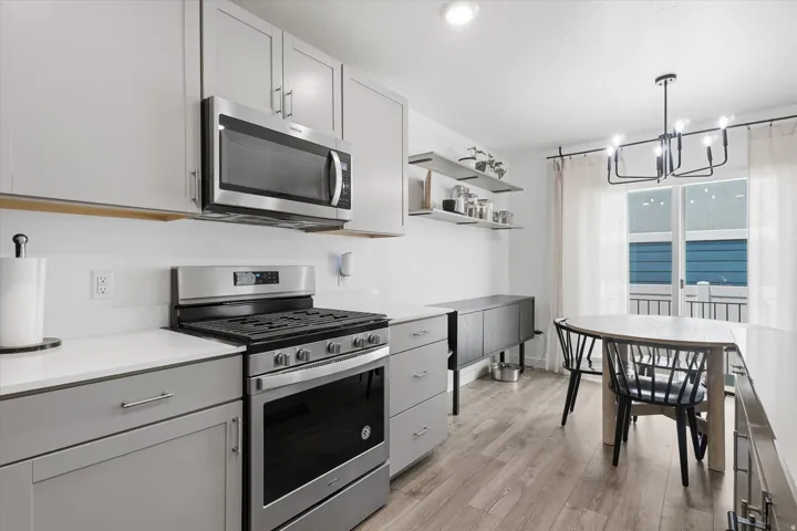 Contemporary kitchen featuring light gray cabinetry, stainless steel appliances, and white countertops