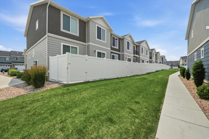 Townhome exterior featuring gray siding, white trim, and dark gray stucco accents