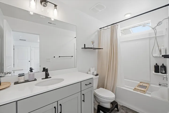 Bathroom featuring a spacious vanity with light gray cabinetry and a white countertop