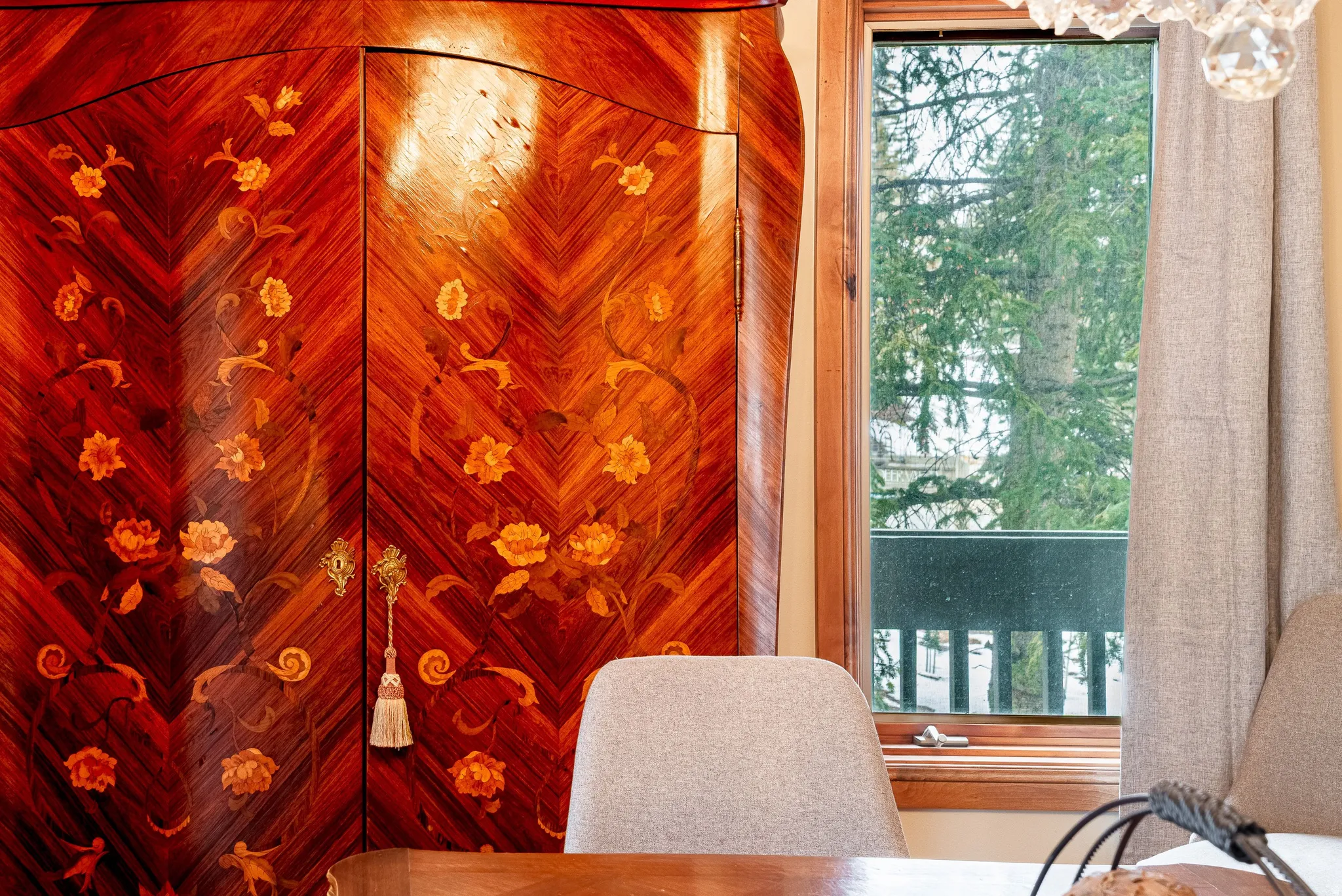 Ornate wooden cabinetry featuring intricate floral marquetry and decorative brass hardware