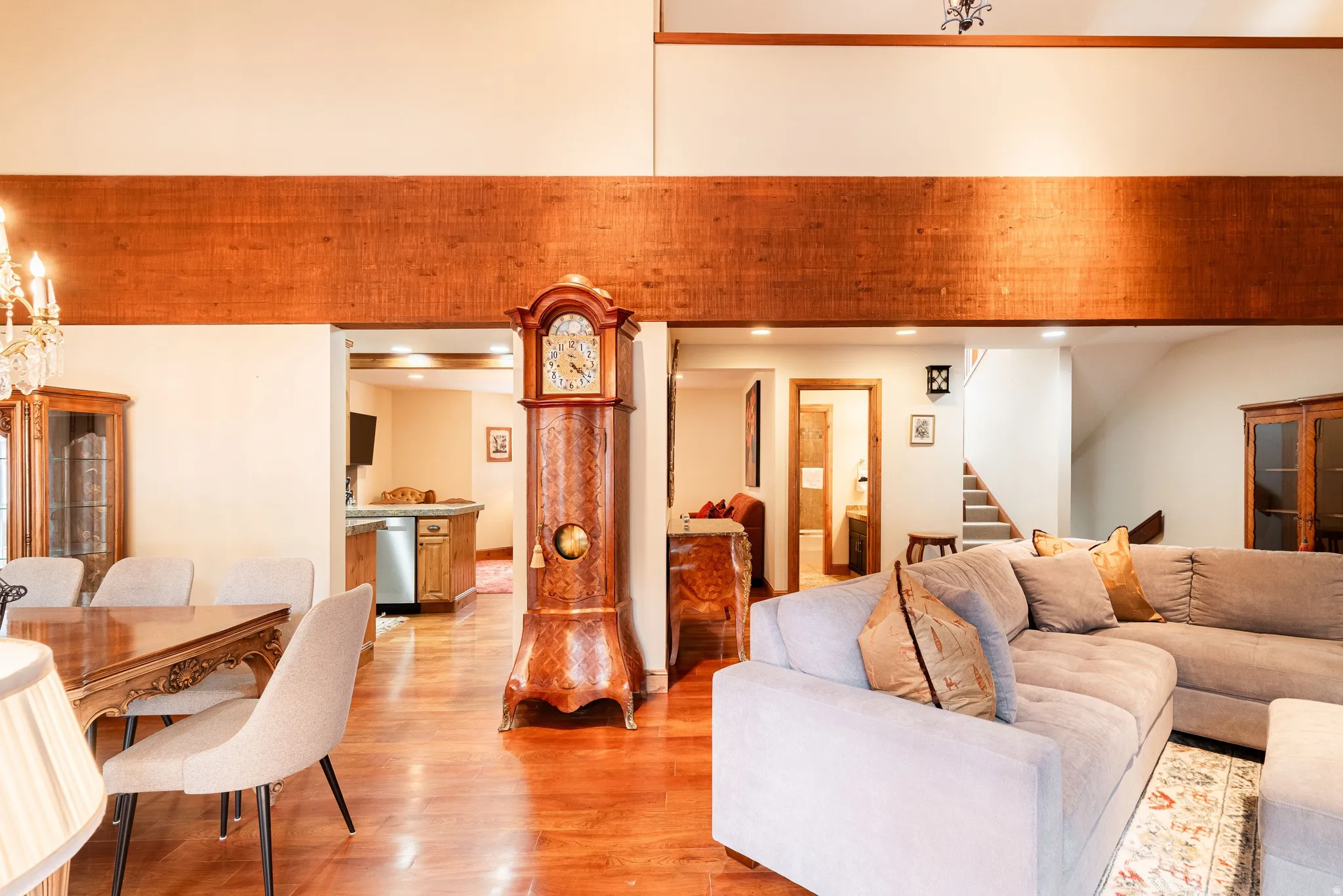 Hardwood-finish flooring throughout, featuring a dining area with a chandelier, a spacious living area, and a staircase