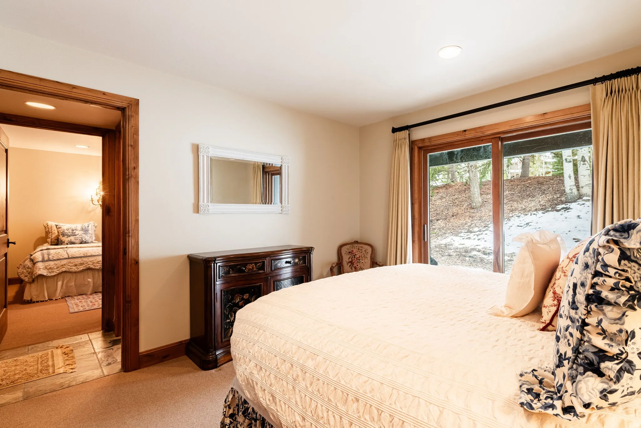 Room featuring light neutral wall paint, recessed lighting, wood-finish sliding glass door with drapes, and a wood-finish interior doorway