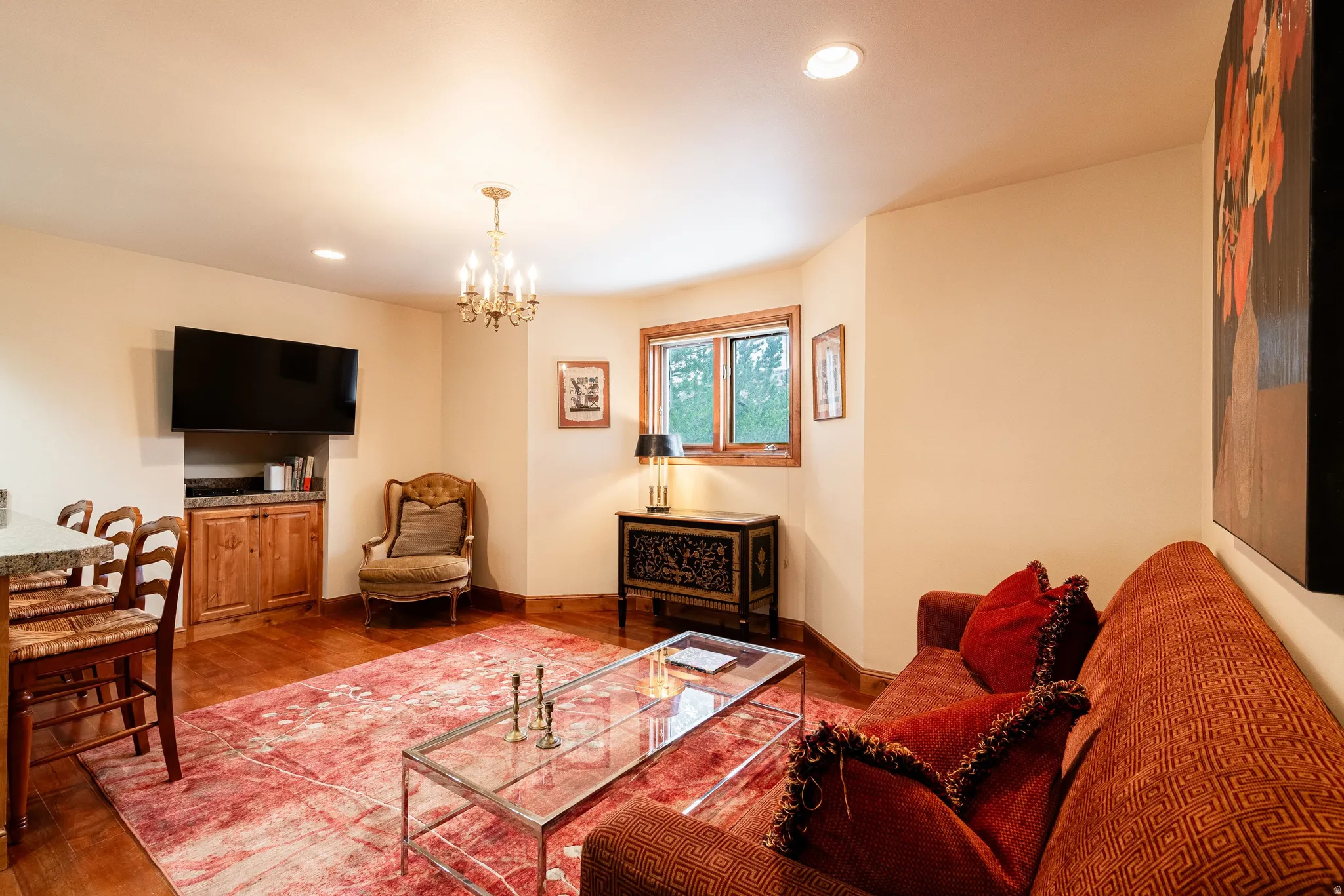 Living area featuring wood-finish flooring, recessed lighting, and a brass-tone chandelier