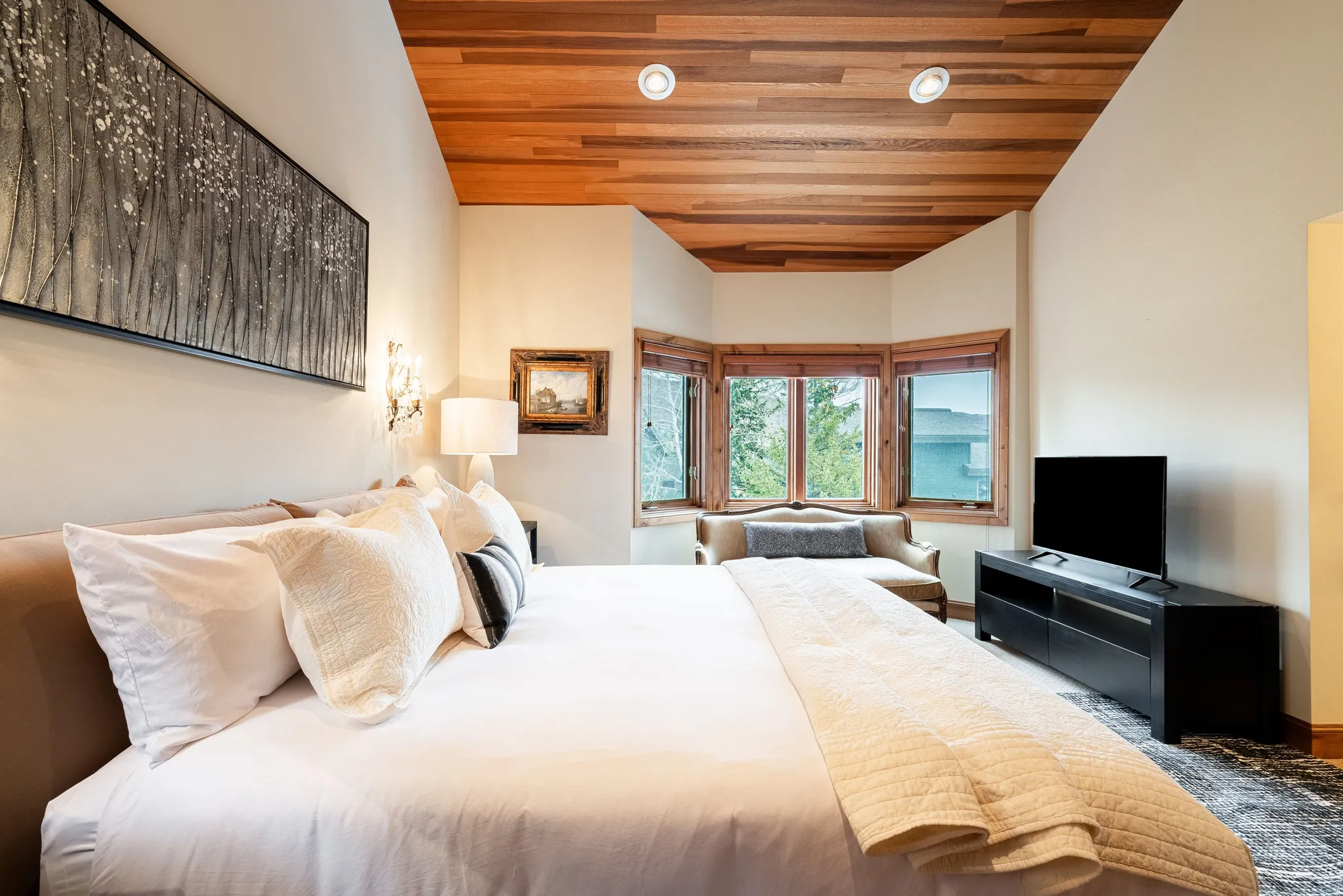 Room featuring a wood-panel ceiling, recessed lighting, and a bay window with wood trim