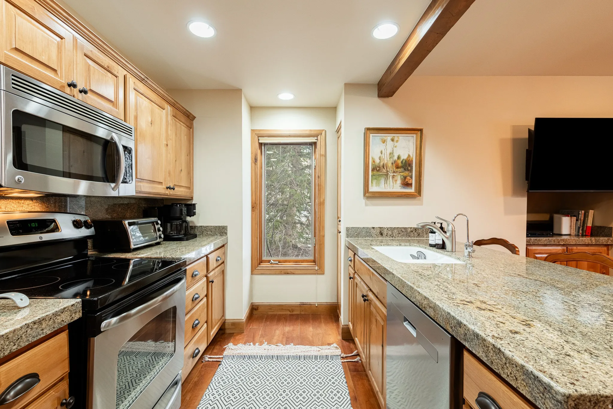 Kitchen featuring wood cabinetry, stainless steel appliances, and granite countertops
