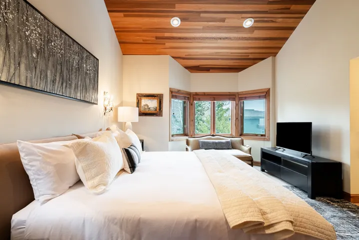 Room featuring a wood-panel ceiling, recessed lighting, and a bay window with wood trim