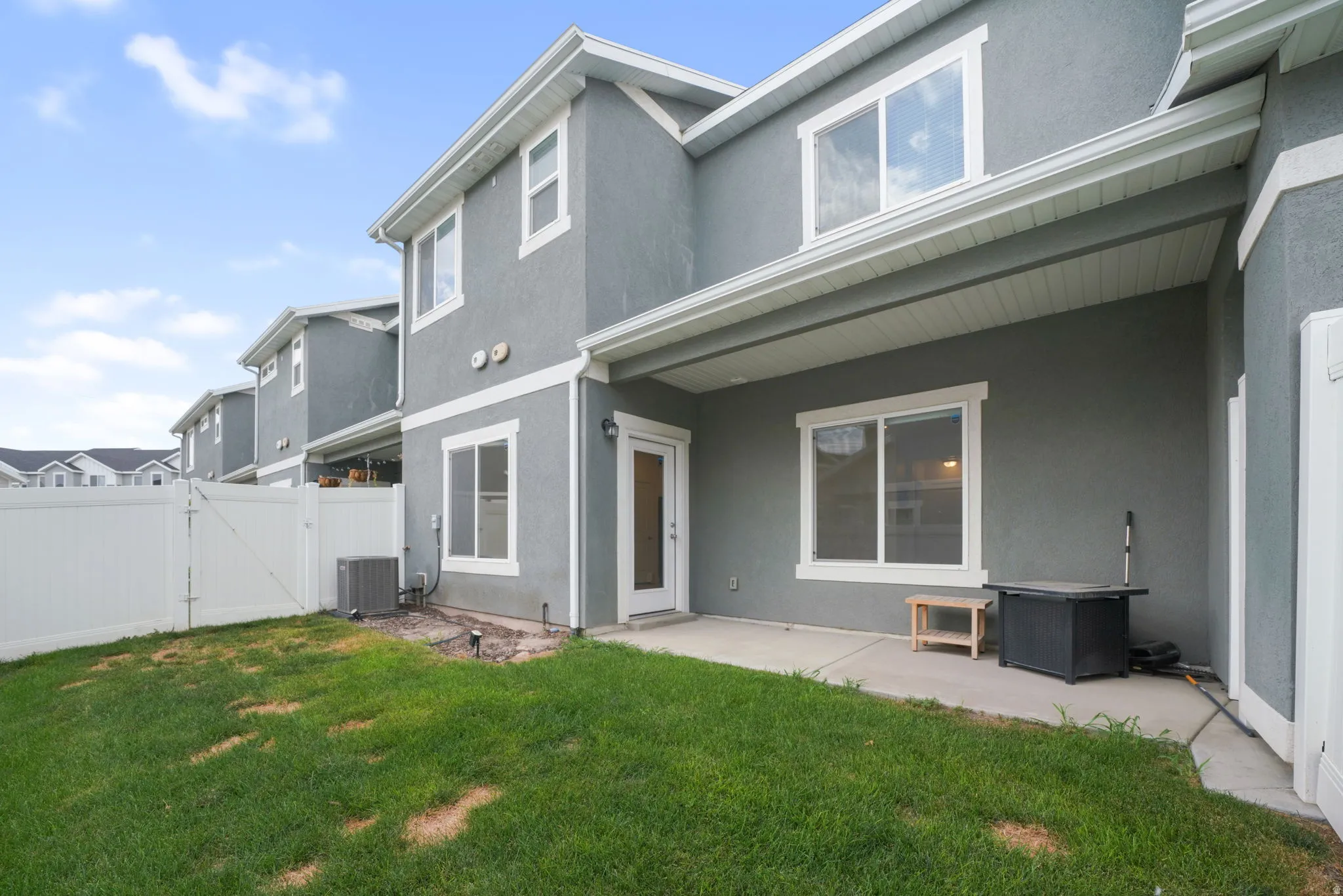 Rear exterior featuring a covered patio, stucco siding, and white trim