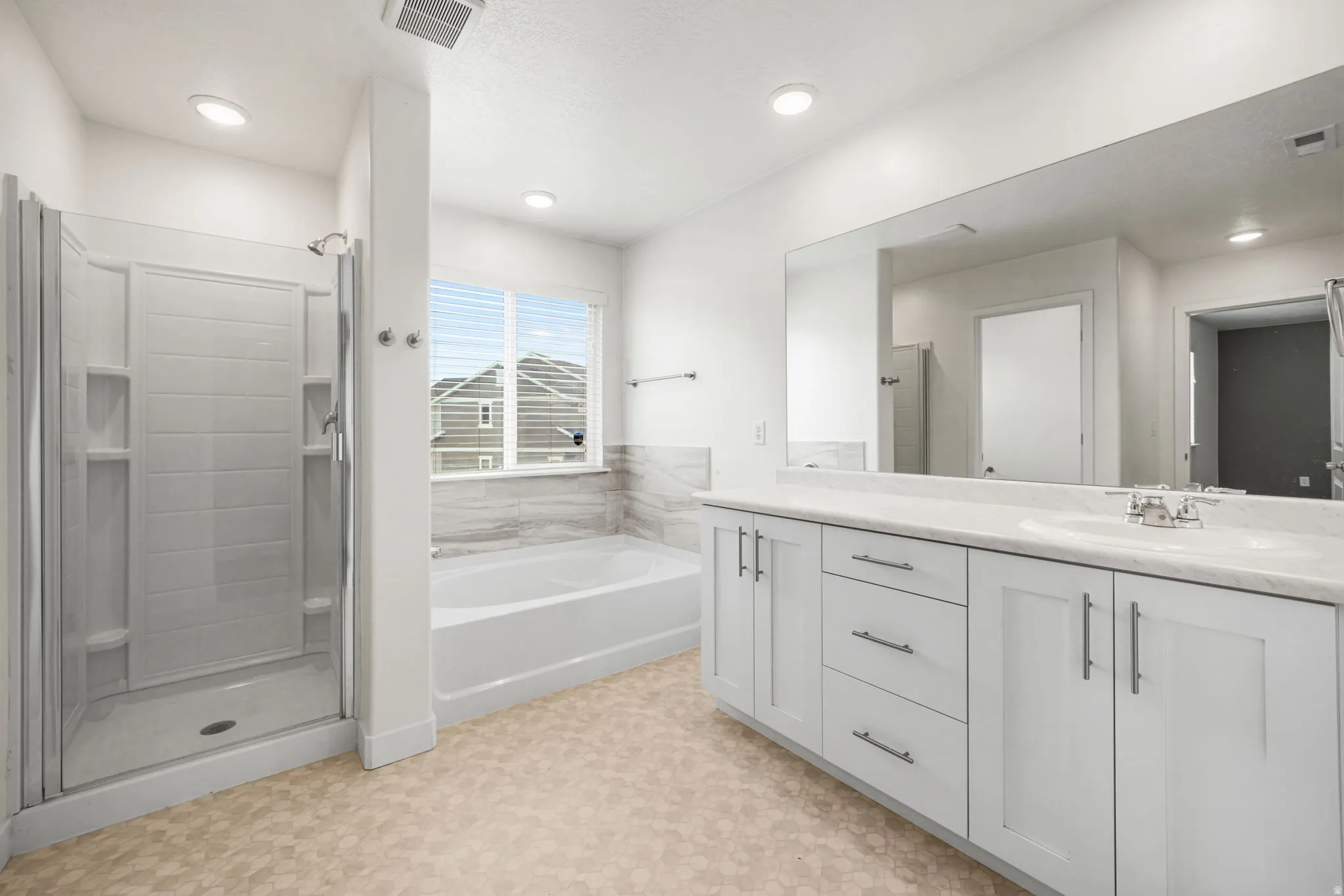 Contemporary bathroom featuring a large shower enclosure, separate soaking tub, and a double vanity with ample storage