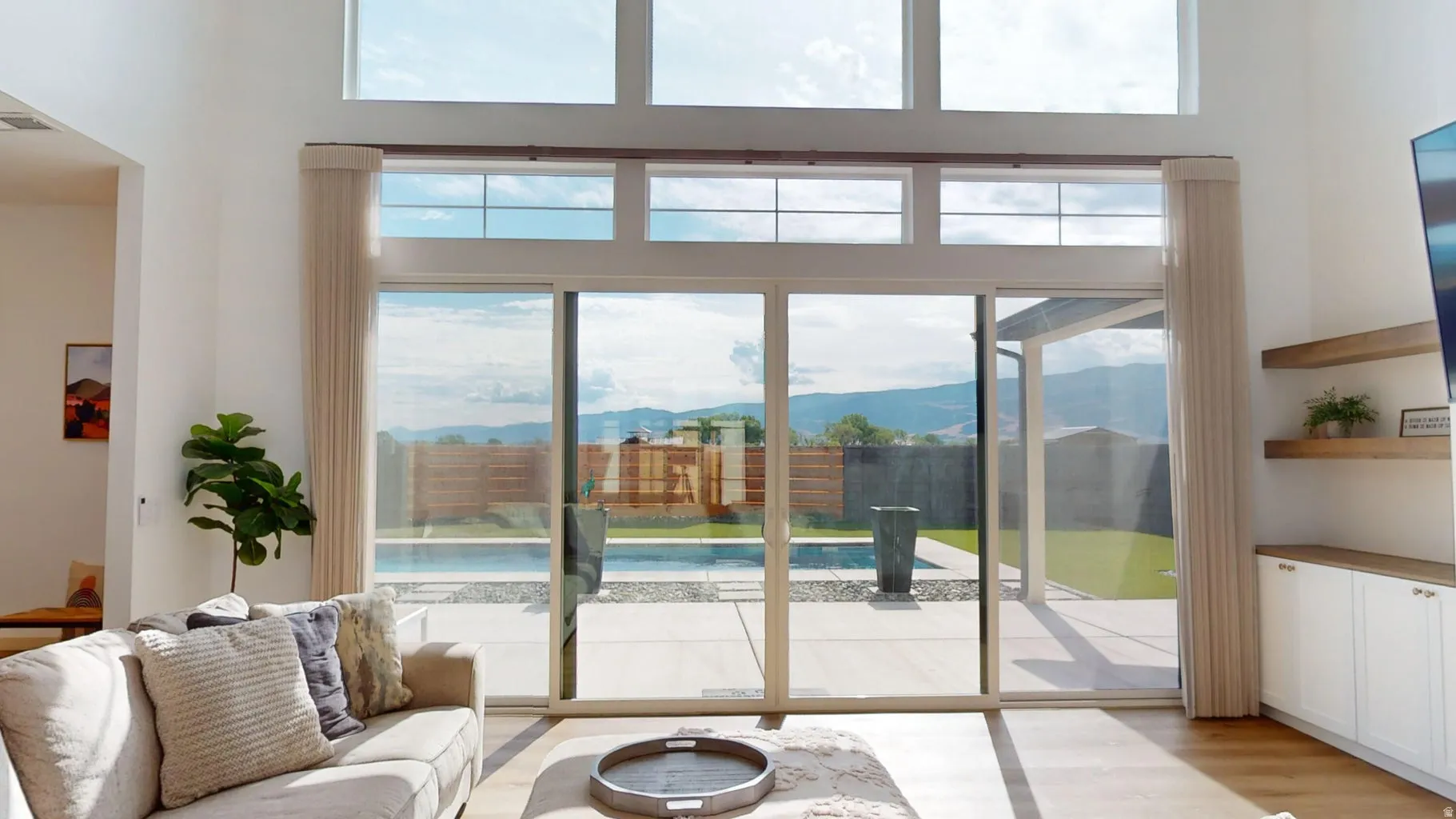 Double-height living space featuring expansive glass sliding doors and transom windows