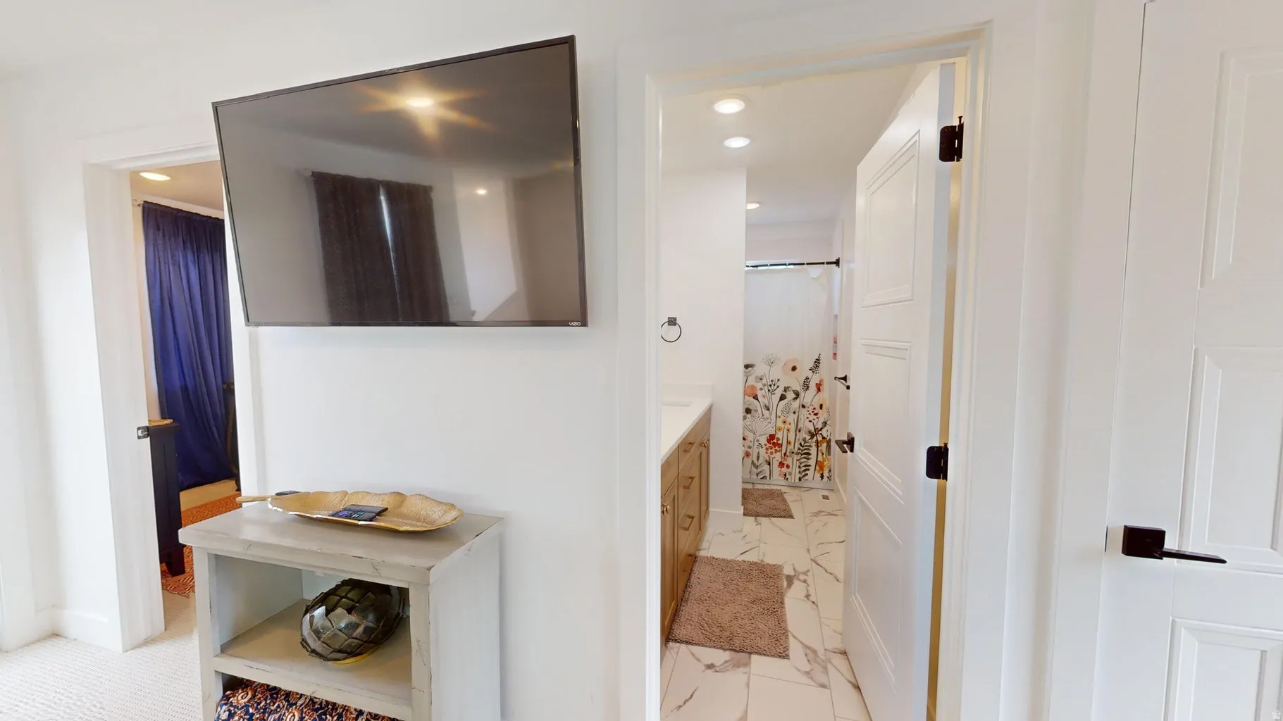 Bathroom featuring a white vanity with an undermount sink, marble-look tile flooring, and recessed lighting