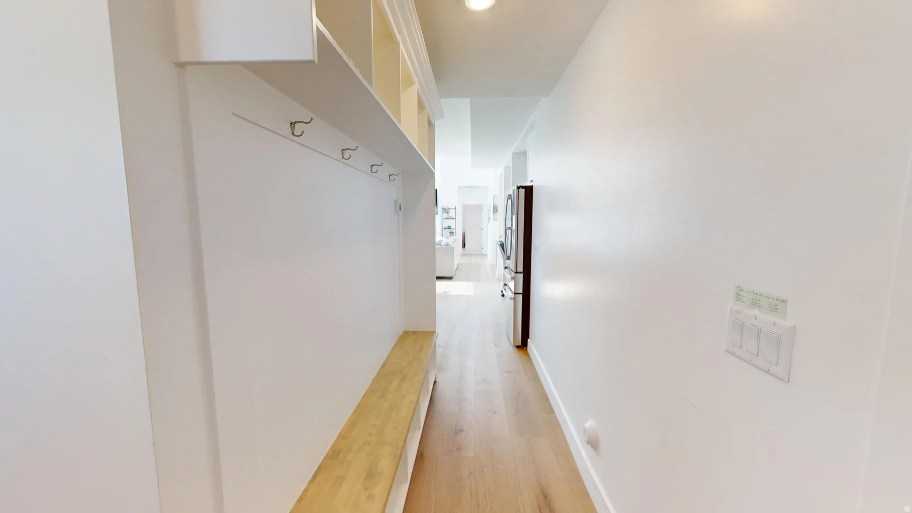 Entryway featuring built-in bench seating with storage, coat hooks, and overhead cubbies