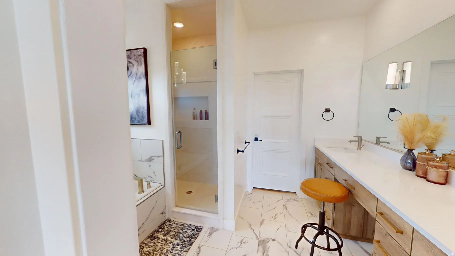 Expansive bathroom featuring a walk-in shower with glass enclosure, a built-in soaking tub with a tiled surround, a lengthy vanity with dual sinks, and large-format porcelain tile flooring