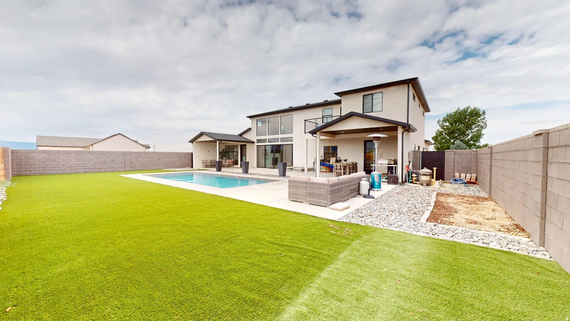 Expansive rear yard featuring an in-ground pool with surrounding paved patio