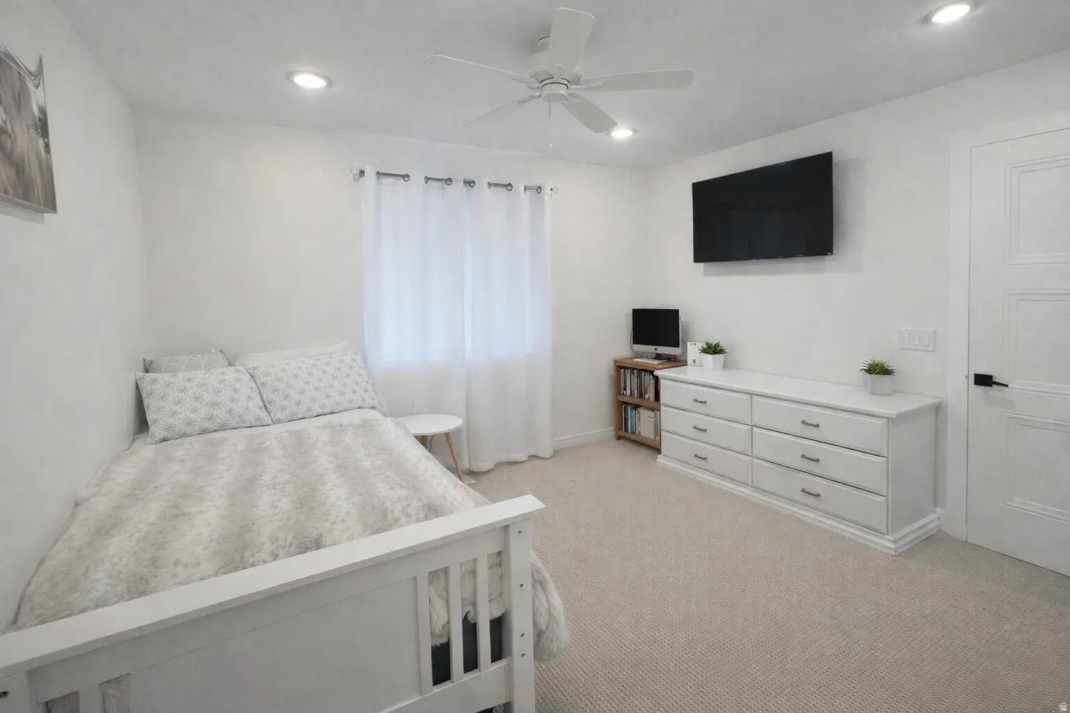 Carpeted room featuring a white ceiling fan with integrated lighting, recessed ceiling lights, and a window with sheer curtains