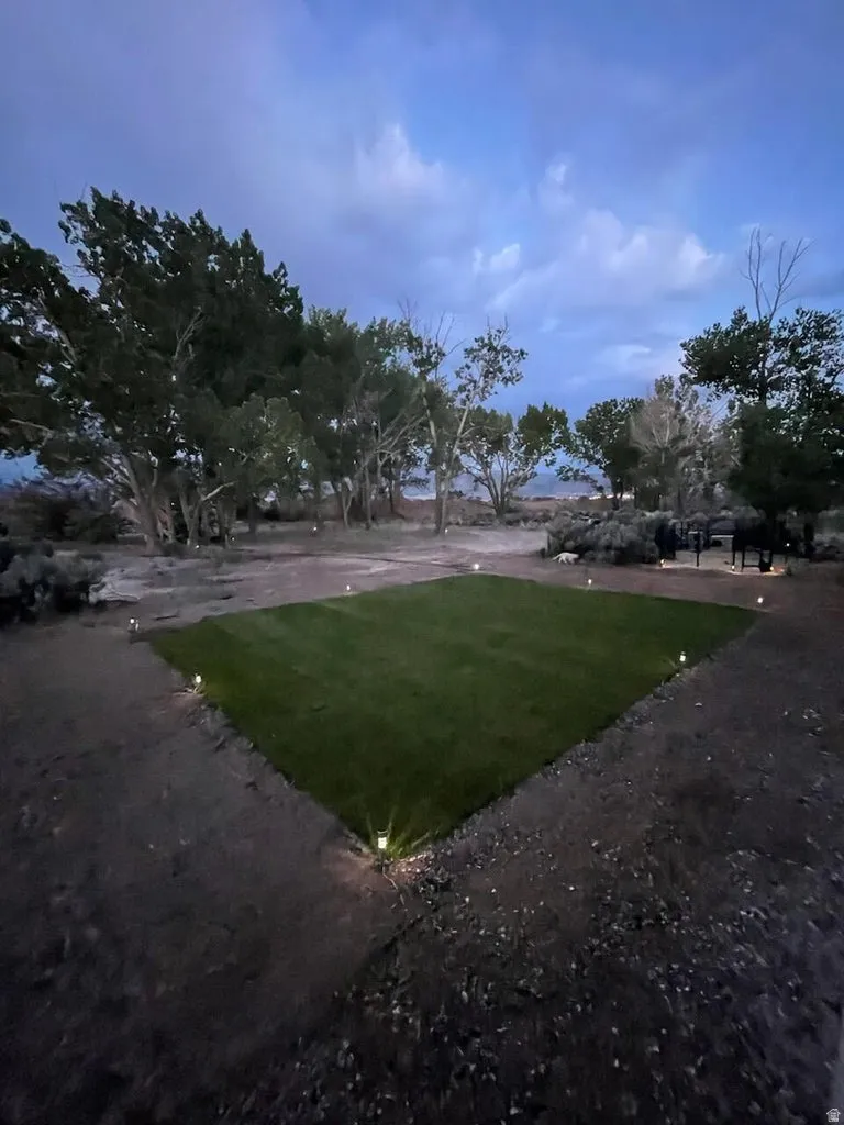 Expansive lawn area with perimeter ground lighting