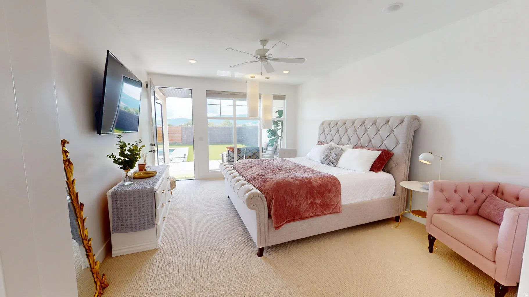 Carpeted interior space featuring a ceiling fan, recessed lighting, and a sliding glass door providing backyard access