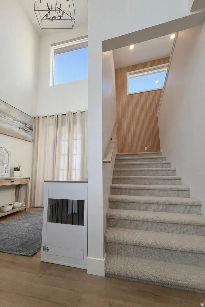 Two-story entryway featuring wood-finish flooring and a carpeted staircase