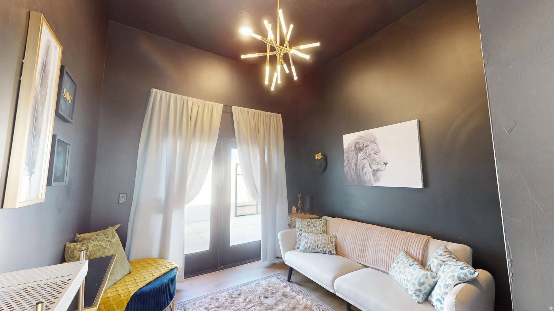 Room featuring a contemporary sputnik chandelier, dark wall finish, and double French doors with sheer white curtains