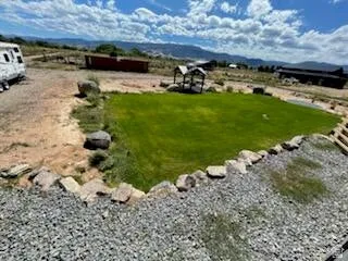 Expansive exterior grounds featuring a central green lawn with a rock border