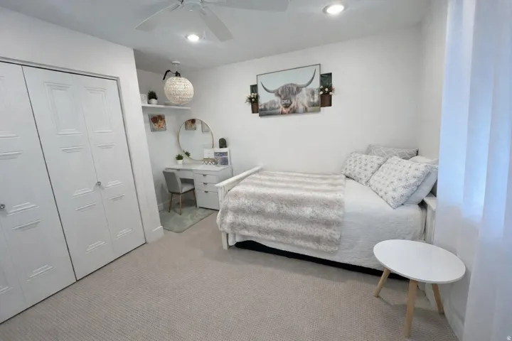 Carpeted room featuring a ceiling fan, recessed lighting, and white bi-fold closet doors