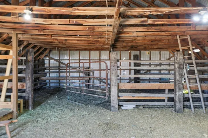 Spacious barn interior featuring exposed wood beams and a slatted wood ceiling