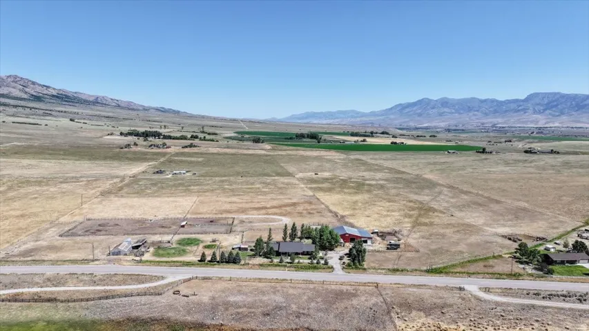 Expansive rural property featuring a main residence, a red barn, and multiple outbuildings